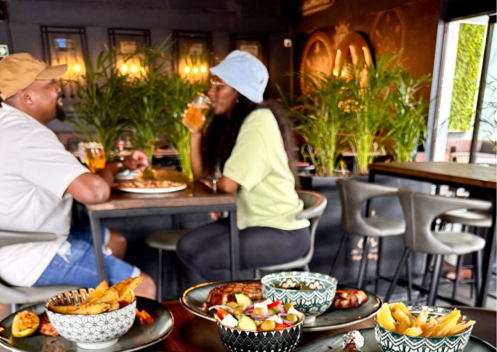 A relaxed and vibrant daytime date where couples can enjoy a sun-drenched lunch of fresh contemporary plates and craft drinks amidst lush greenery and modern urban decor.